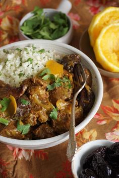 a white bowl filled with rice and meat next to bowls of oranges, raisins and cilantro