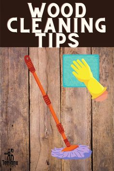 a wooden fence with a hand holding a mop and duster on top of it