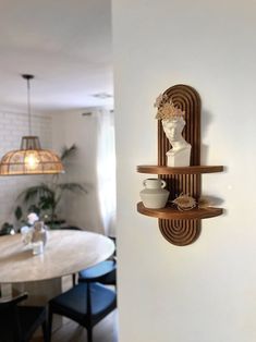 a wall mounted shelf next to a dining room table