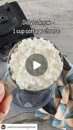 someone is holding a knife over a bowl of cottage cheese