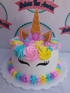 there is a cake decorated with flowers and an unicorn's face