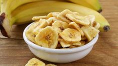 a white bowl filled with sliced bananas on top of a wooden table