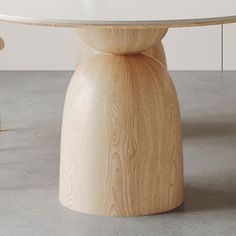 a round table with two stools in front of it and a white wall behind it