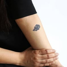 a woman's arm with a tattoo on it that has an elephant and clouds