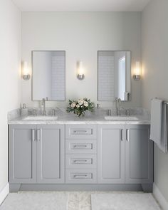 a bathroom with double sinks and two mirrors on the wall next to eachother