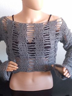 a mannequin wearing a gray knitted sweater with openwork on the shoulders