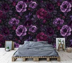 a bed sitting in front of a purple flower wallpaper on top of a wooden floor