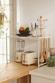 a kitchen counter with food and utensils sitting on it's shelf next to a window