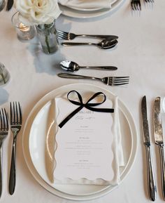 the table is set with silverware and place settings