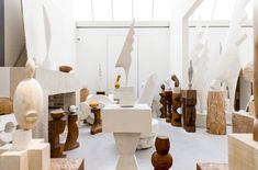 a room filled with lots of wooden sculptures