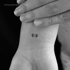 a woman's wrist with a small tattoo on it