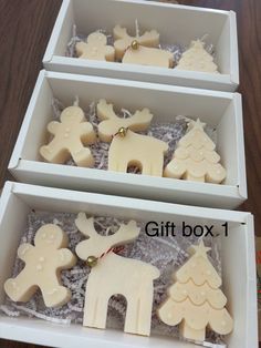 two white boxes filled with christmas cookies on top of a wooden table