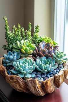 a wooden bowl filled with lots of succulents on top of a table