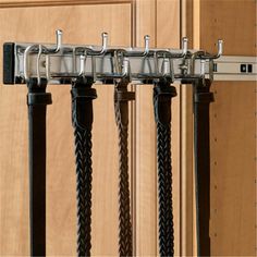 four black and silver poles are hanging on the wall in front of a wooden door