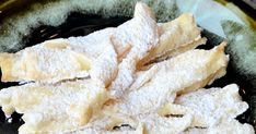 some powdered sugar sticks are on a black and yellow plate with green trim around the edges