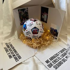 a soccer ball in a cardboard box with some pictures on the front and back side