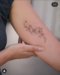 a woman's arm with a flower tattoo on it