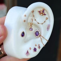 a person holding a fake ear with jewelry on it