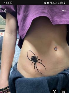 a woman with a spider tattoo on her stomach