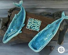 two blue whale shaped dishes sitting on top of a wooden table