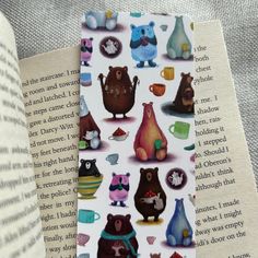 a bookmark with bears on it sitting next to an open book