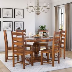 a dining room table and chairs with pictures on the wall