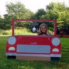 a woman is sitting in a toy car