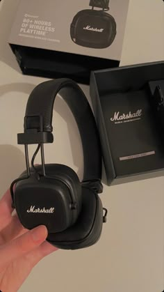 a pair of black headphones sitting on top of a table next to a box