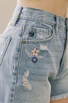 the back of a woman's jean shorts with flowers on it