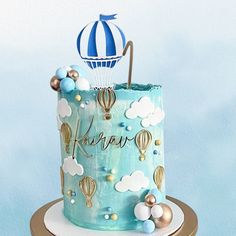 a blue and gold birthday cake with hot air balloons