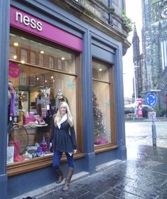 a woman standing in front of a store window