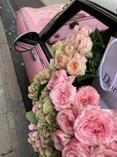 a pink car with flowers on the front and back seat is parked next to a parking meter