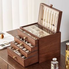 an open wooden jewelry box sitting on top of a table