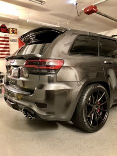 an suv parked in a garage next to another car