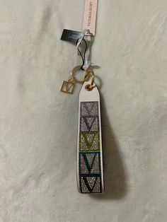 a keychain that has been decorated with the word love and is hanging on a white sheet