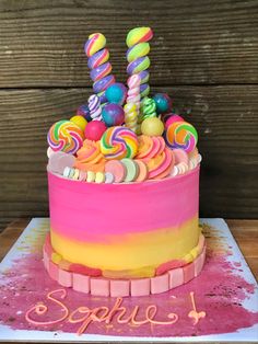 a birthday cake decorated with candy and lollipops