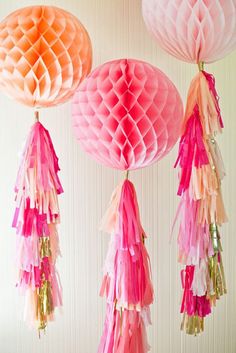 some pink and orange paper lanterns hanging from the ceiling