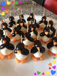 there are many penguin cupcakes on the plate with toothpicks in them