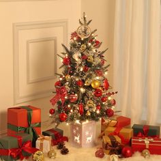 a small christmas tree surrounded by presents