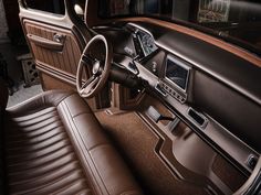 the interior of an old car with brown leather seats and dashboard, including steering wheel