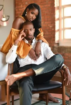 a man sitting next to a woman on top of a chair