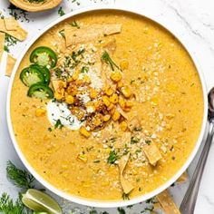 a white bowl filled with soup and garnished with tortilla chips on top