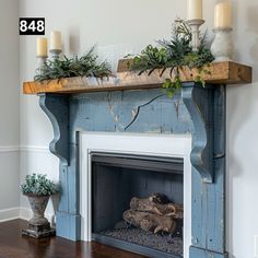 a blue fireplace with candles and greenery on top