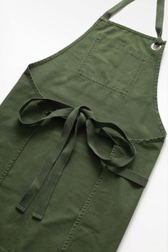 an apron with a tie on the front and side, sitting on a white surface