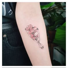 a woman's arm with a bouquet of flowers tattoo on the left inner arm