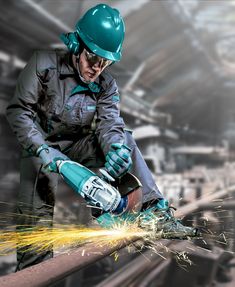 a man in safety gear grinding metal with a grinder