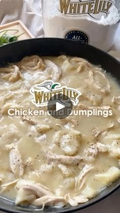 chicken and dumplings cooking in a skillet on top of a table next to a bag of chips