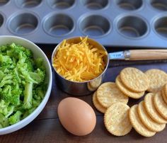 an assortment of food including broccoli, cheese and crackers on a table