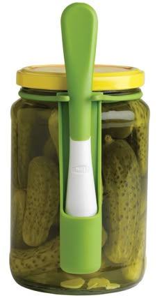 a jar filled with pickles next to a knife