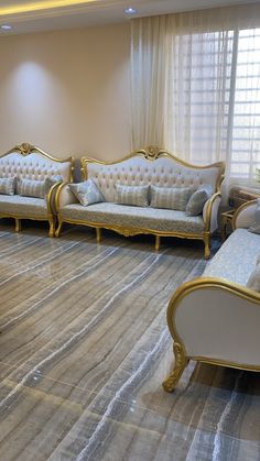 a living room filled with lots of couches next to a window covered in curtains